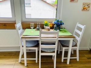 een eettafel met vier stoelen en een groene tafel bij SWEETHOME am WOOGBACH Speyer in Speyer