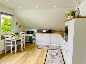 een keuken met witte kasten en een tafel en stoelen bij SWEETHOME am WOOGBACH Speyer in Speyer