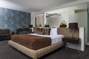 a bedroom with a large bed and a couch at Gamma Morelia Belo in Morelia