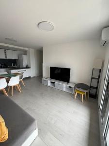 a living room with a television and a table and chairs at Appartement tout confort & Parking in Beausoleil +17 photos