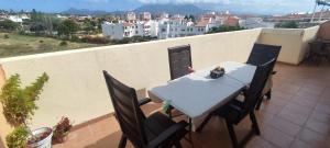 ein Tisch und Stühle auf einem Balkon mit Aussicht in der Unterkunft Ático - CENTRO de Sabinillas - Calle la Pasionaria - in San Luis de Sabinillas