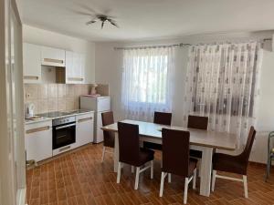 a kitchen with a dining room table and chairs at Apartmani Ana in Sukošan