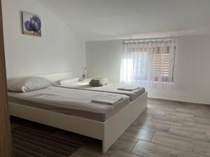 a bedroom with a large bed and a window at Apartmani Ana in Sukošan