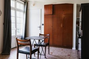 a dining room with a table and two chairs at Appartement les Glycines - Accès Piscine in Criel-sur-Mer
