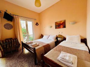 a bedroom with two beds and a window at Retro Rooms in Loutra Edipsou