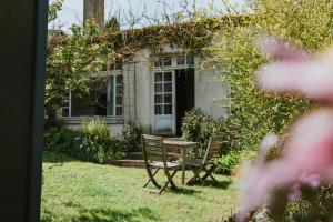 a table and chairs in front of a house at Appartement les Glycines - Accès Piscine in Criel-sur-Mer
