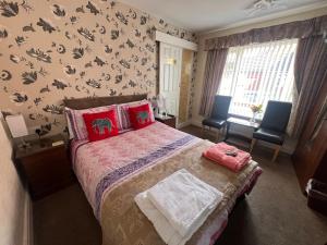 a bedroom with a bed and two chairs in it at The Northdale Hotel Ltd in Skegness