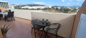 eine Terrasse mit Tisch und Stühlen auf einem Balkon in der Unterkunft Ático - CENTRO de Sabinillas - Calle la Pasionaria - in San Luis de Sabinillas