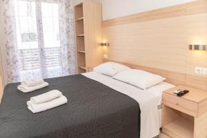 a bedroom with a bed with two towels on it at Antonia's Apartments in Kassiopi