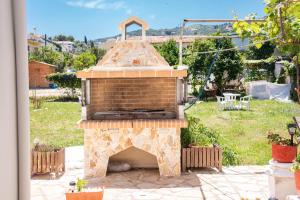 a outdoor pizza oven in a yard with a patio at Antonia's Apartments in Kassiopi +30 photos