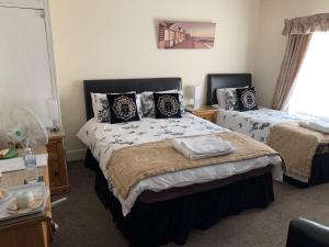 a bedroom with two beds and a window at The Northdale Hotel Ltd in Skegness