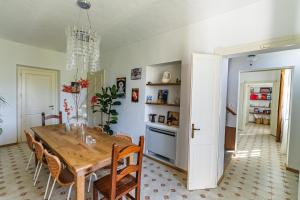 a dining room with a wooden table and chairs at Bed & Breakfast Barbera e Tulipani in Scandeluzza