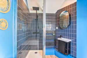 a blue tiled bathroom with a shower and a sink at Charming seaside house in Varaville +12 photos