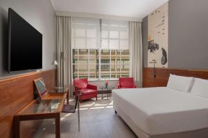 pokój hotelowy z łóżkiem i telewizorem w obiekcie NH Torino Lingotto Congress w Turynie