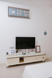 a living room with a tv on a white wall at Fiyala Homestay in Feydhoo