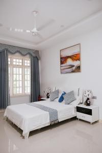 FeydhooにあるFiyala Homestayの白いベッドルーム(ベッド2台、窓付)