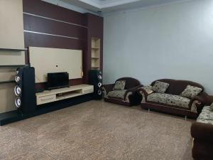 a living room with two couches and a flat screen tv at Villa Rashensa in Paragajen