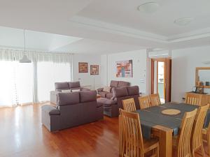 ein Wohnzimmer mit einer Couch und einem Tisch und Stühlen in der Unterkunft Casa en Granada zona residencial El Serrallo in Granada