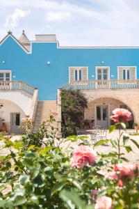 a blue house with flowers in front of it at Agriturismo Masseria Calongo in Cisternino