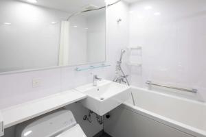 W białej łazience znajduje się umywalka i lustro. w obiekcie Comfort Hotel Matsuyama w mieście Matsuyama