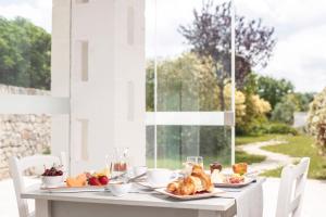 a table with a breakfast of croissants and pastries at Agriturismo Masseria Calongo in Cisternino