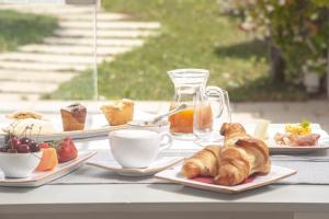a table topped with plates of pastries and cups of coffee at Agriturismo Masseria Calongo in Cisternino +38 photos