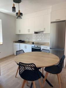 Una cocina con mesa y sillas y un refrigerador. en O Mirador Alere Carnota playa, en San Mamede de Carnota