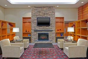 a lobby with a fireplace with couches and a tv at Grand Park Hotel Vancouver Airport, Ascend Hotel Collection in Richmond