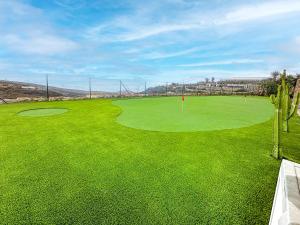 a view of a golf course with a green at Exquisite rural house with garden, pool and sea views in Arico Viejo +72 photos
