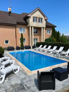 a swimming pool with lounge chairs and a house at OW Delta in Rewal