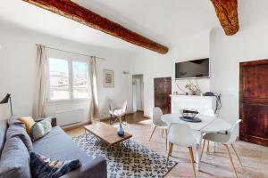 una sala de estar con un sofá y una mesa en Le Pǐgeonnier - Un Voyage En Provence, en Aix-en-Provence