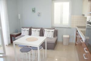 a living room with a couch and a table and chairs at Beachside Babe in Novalja +19 photos
