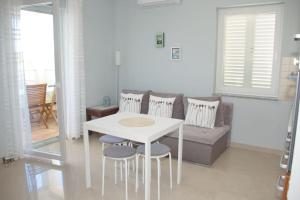 a white table and chairs in a living room with a couch at Beachside Babe in Novalja