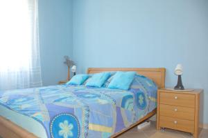 a blue bedroom with a bed and a night stand at Beachside Babe in Novalja