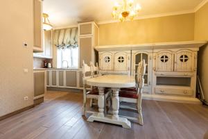 a dining room with a table and chairs and a kitchen at Sofijos apartamentai in Klaipėda