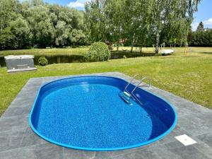 a blue swimming pool sitting on top of a yard at Hotel Mazury in Giżycko