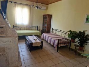 a living room with two beds and a table at Mountain Breeze Cottage in Makriótika