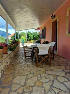 a stone patio with a table and chairs on a house at Mountain Breeze Cottage in Makriótika