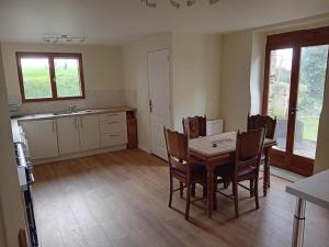 a kitchen with a table and chairs in a room at Les Gites Audrain in Plussulien +20 photos