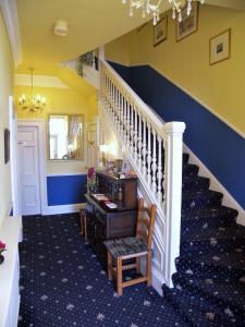 a hallway with a staircase with blue and yellow walls at Ardleigh House in Edinburgh