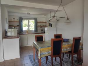 a kitchen with a table and chairs and a kitchen with a refrigerator at La Tulipe **** in Savines +23 photos
