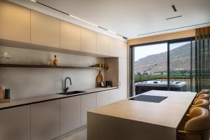 a kitchen with a sink and a large window at The Nine Villas in Migdal