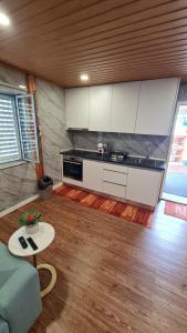 une cuisine avec des armoires blanches et une table dans une pièce dans l'établissement Alojamento São Brás, à São Brás