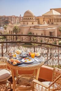 a breakfast table on a balcony with a view of a city at Opera Plaza Hotel Marrakech in Marrakech