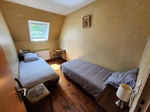 Le DézertにあるMaison au calme, idéalement située au centre du Cotentinのベッド2台と窓のある寝室