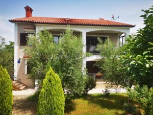 a house with trees in front of it at Garden Apartment Maria in Vrsar