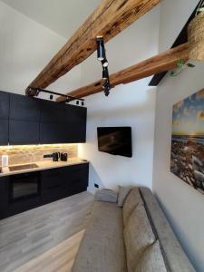 a living room with a couch and a kitchen at Courtyard Condo Sunset in Liepāja +11 photos