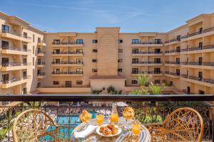 a balcony with a table with food and orange juice at Opera Plaza Hotel Marrakech in Marrakech