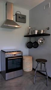a kitchen with a stove and a shelf with pots and pans at Villa La Mercy Maisonette -No load shedding or water outage in La Mercy