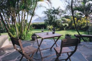 a table and two chairs with wine glasses on a patio at Villa La Mercy Maisonette -No load shedding or water outage in La Mercy